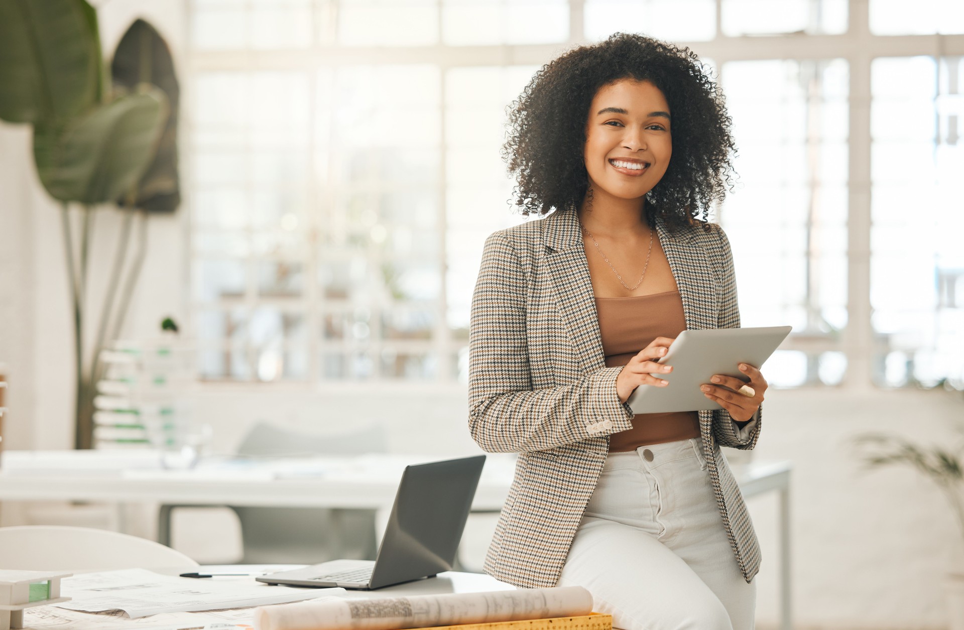 Femme d’affaires heureuse utilisant une tablette numérique. Jeune femme d’affaires de premier plan utilisant une tablette sans fil. Designer créative travaillant dans son agence. Designer debout dans son bureau à l’aide d’une application en lign